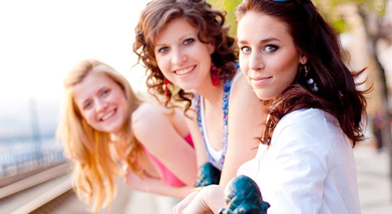 tres chicas: una rubia, una morena y una pelirroja.