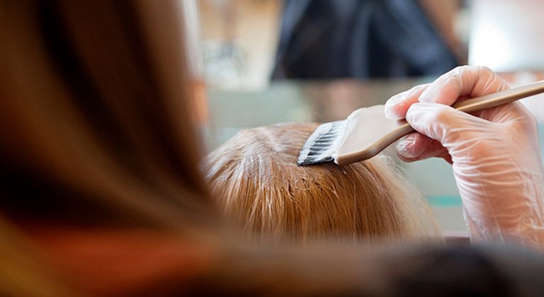 mujer tiñendo la raíz a otra