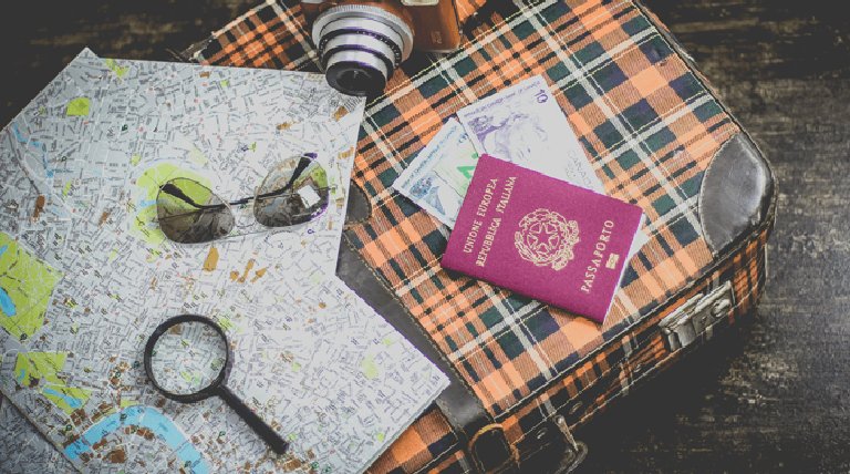 maleta pasaporte mapa lupa cámara de fotos gafas de sol 