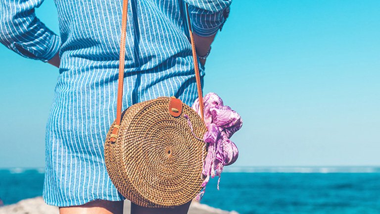 mujer con bolso de rabia frente al mar
