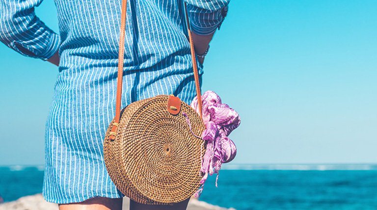 mujer con bolso de rabia frente al mar