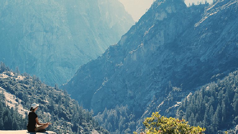 Mujer meditando en la montaña