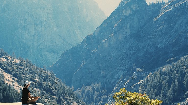 Mujer meditando en la montaña
