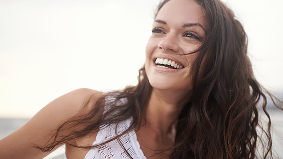 mujer morena de pelo largo rizado riéndose