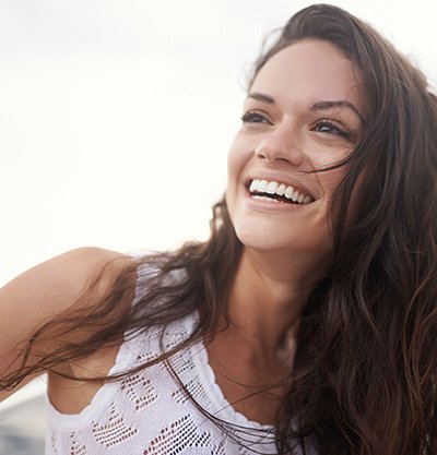 mujer morena de pelo largo rizado riéndose