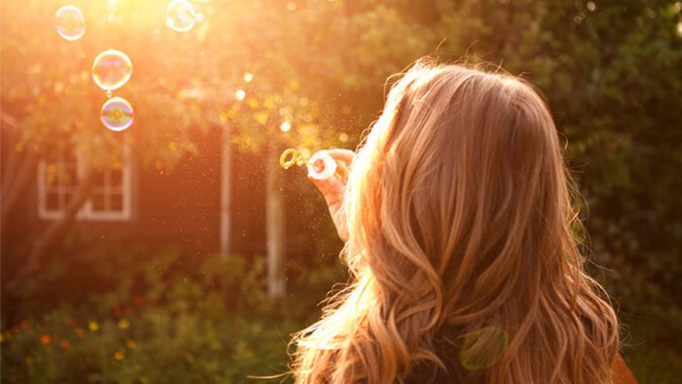 mujer haciendo pompas de jabón 