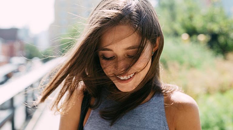 mujer morena pelo liso al viento
