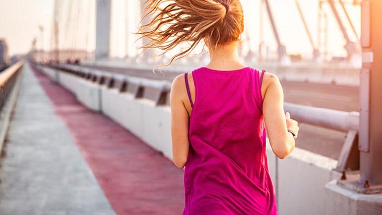 mujer pelo largo recogido corriendo vista de espaldas