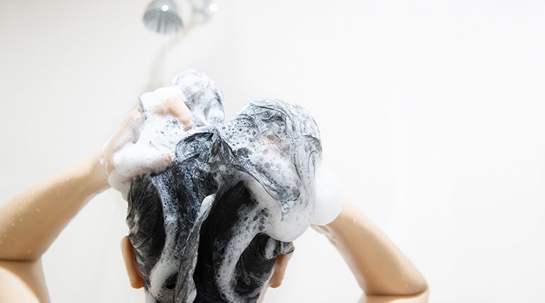 mujer lavándose el pelo
