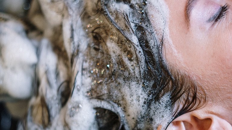 mujer lavándose el pelo