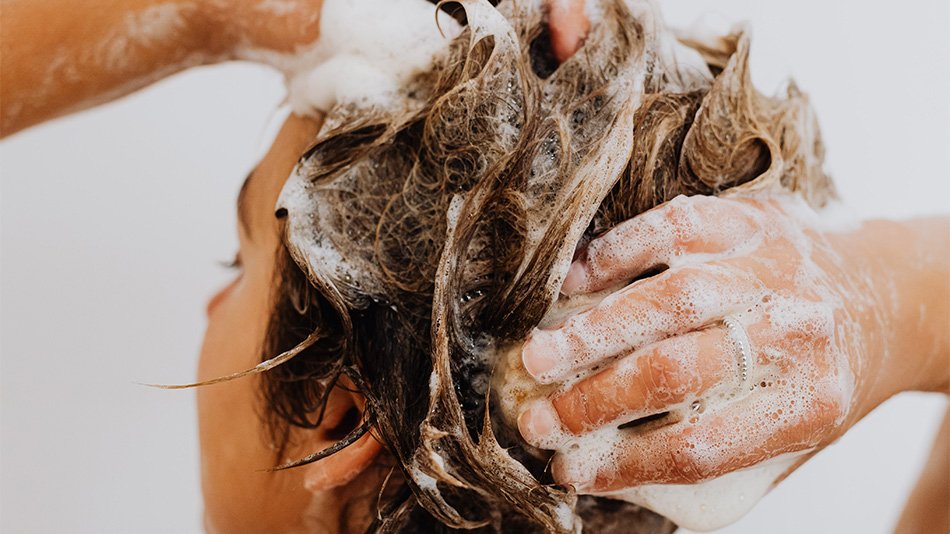 mujer lavándose el pelo