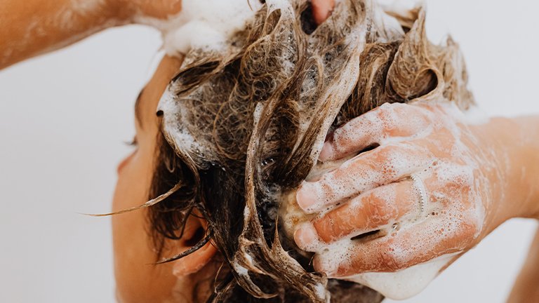 mujer lavándose el pelo