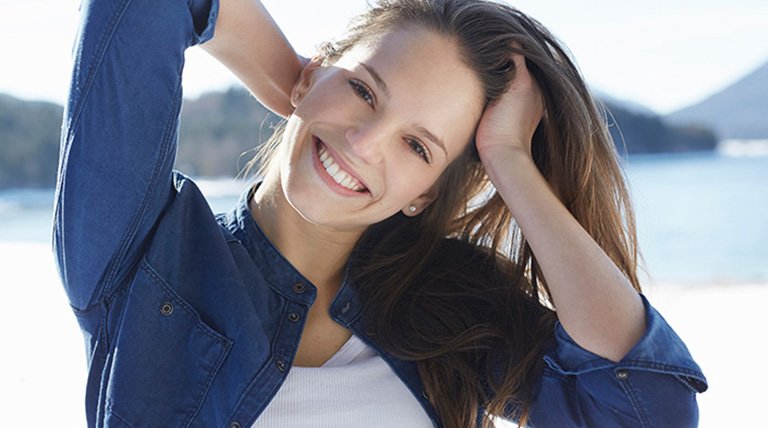 Mujer sonriendo tocándose el pelo