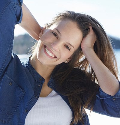 Mujer sonriendo tocándose el pelo