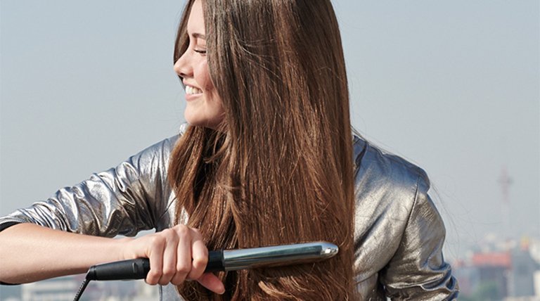 mujer morena planchándose el pelo