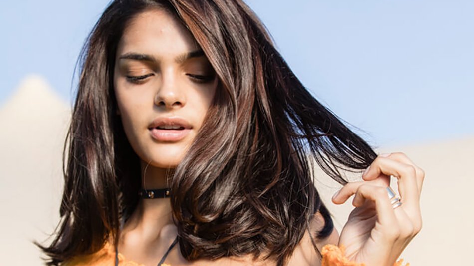 mujer morena con media melena tocándose el pelo