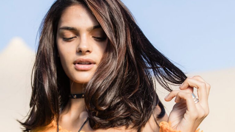 mujer morena con media melena tocándose el pelo