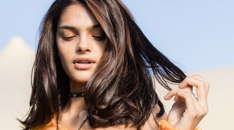 mujer morena con media melena tocándose el pelo