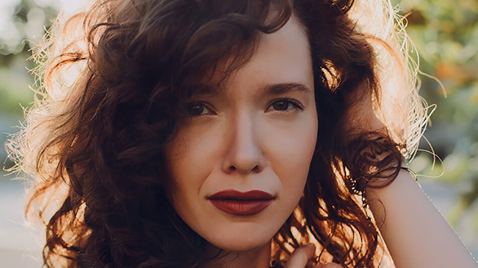 mujer de pelo negro rizado y labios pintados