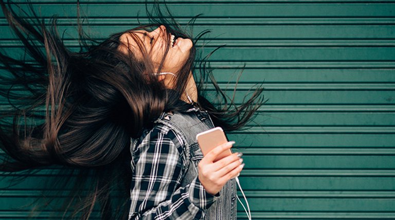 mujer pelo largo escuchando música con auriculares