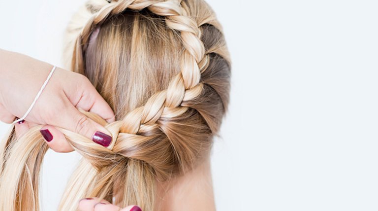 Mano recogiendo trenza sobre cabeza femenina