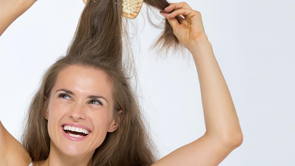 Mujer alegre peinando larga cabellera