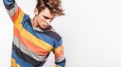 Hombre joven con jersey de colores y pelazo