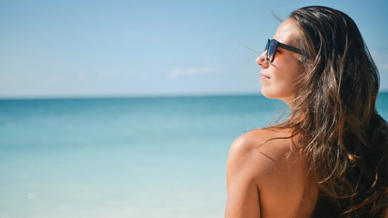 Mujer con gafas de sol bronceándose