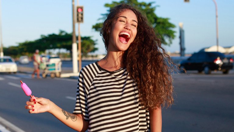 Mujer alegre con pelo largo y rizado