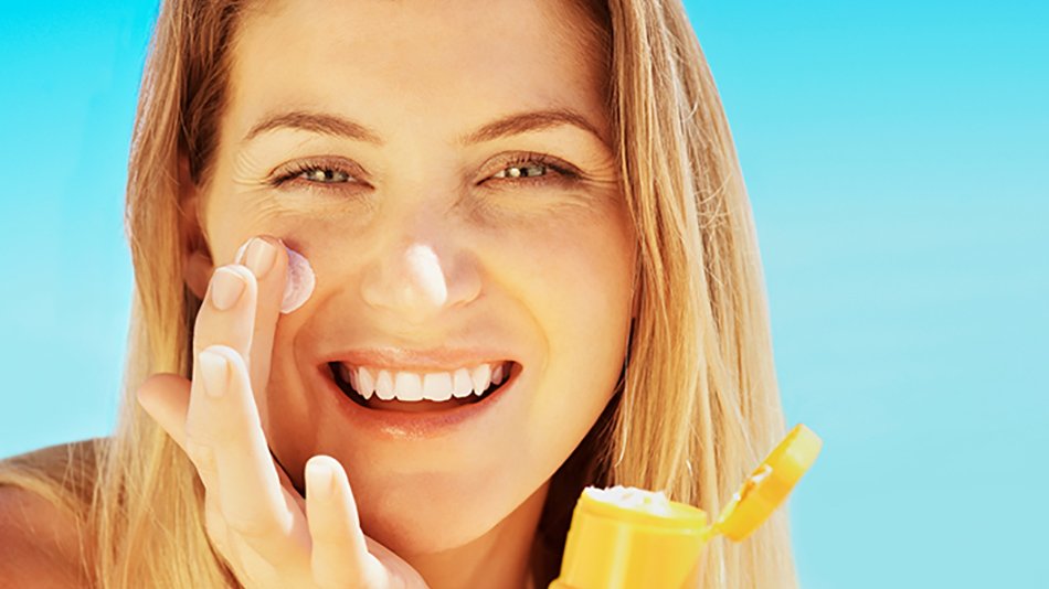 Mujer poniéndose crema en la cara