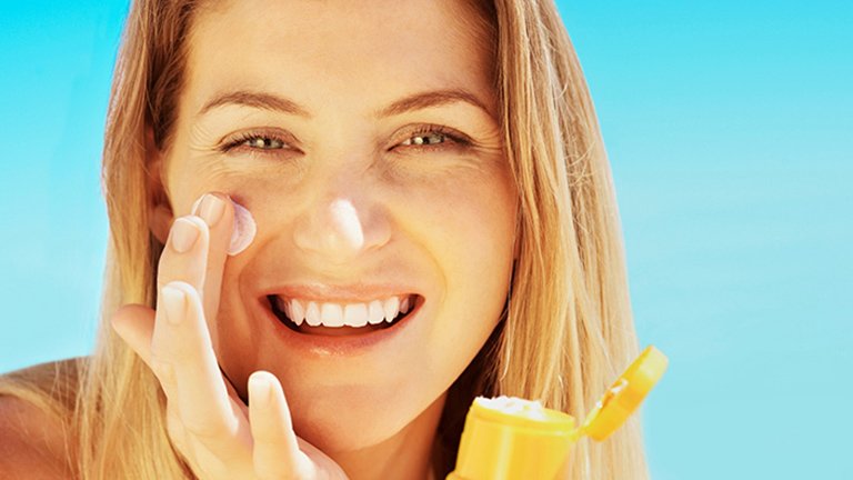 Mujer poniéndose crema en la cara