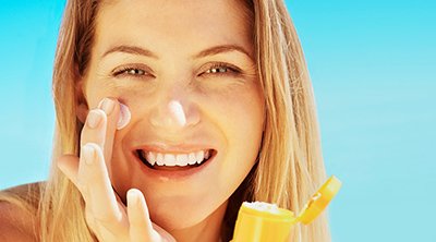 Mujer poniéndose crema en la cara