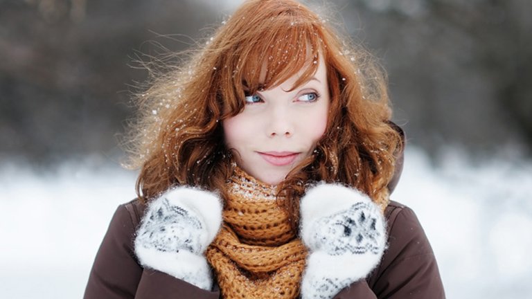 Mujer pelirroja abrigada en exterior frío