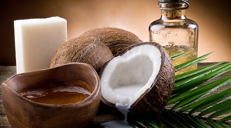 Cocos, alguno abierto y frasco de aceite