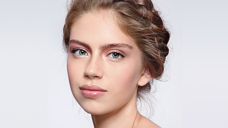 Rostro de mujer joven con trenza en moño