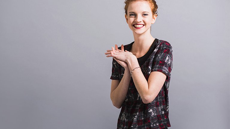 Mujer joven sonriente, cruzando las manos