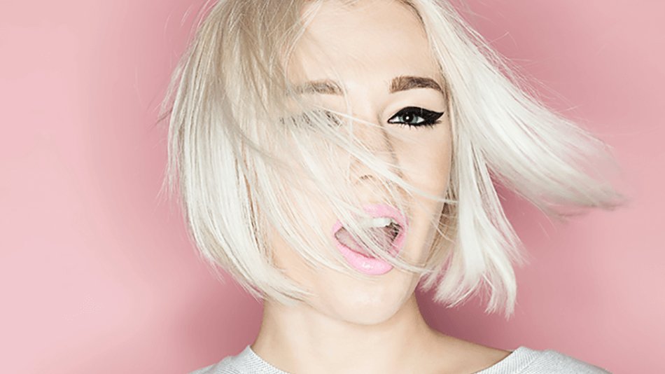 Rostro de mujer con parte del cabello rubio tapándole el rostro