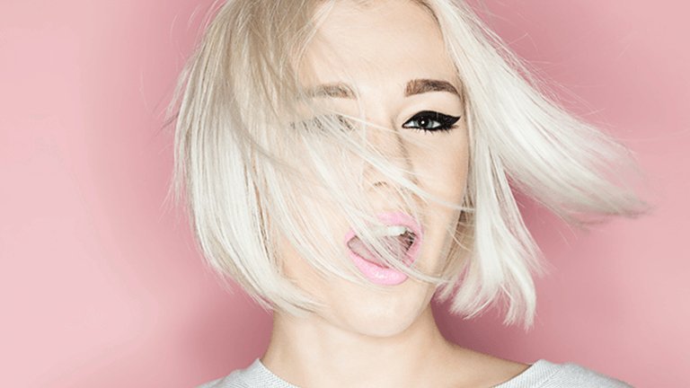 Rostro de mujer con parte del cabello rubio tapándole el rostro