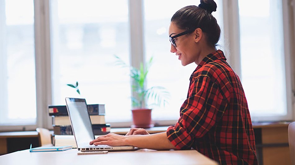 Mujer trabajando en ordenador con pelo recogido en moño