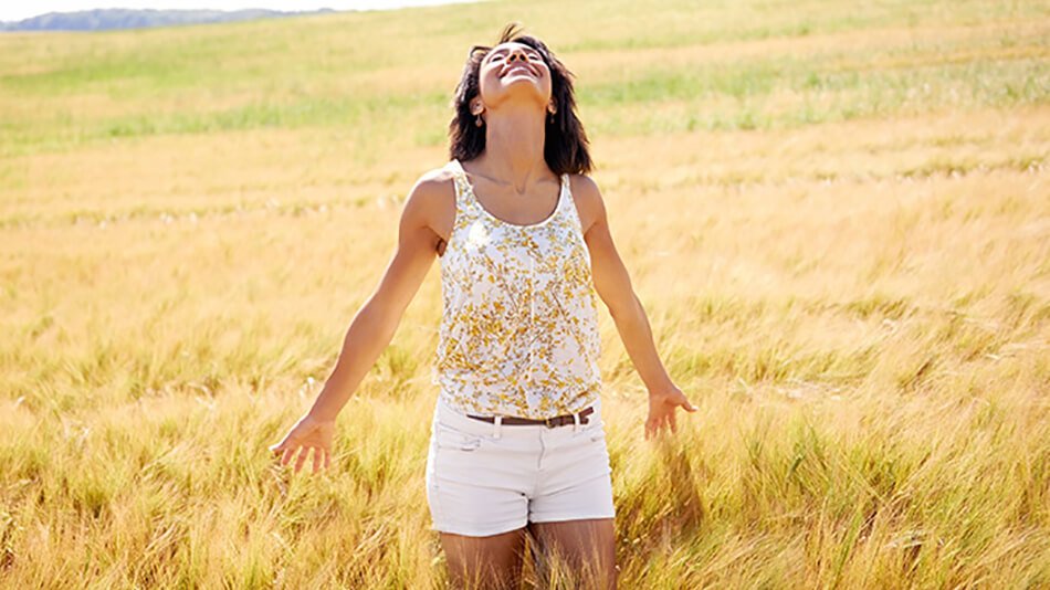 Mujer feliz paseando por campo