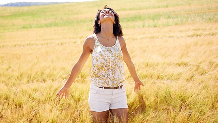Mujer feliz paseando por campo