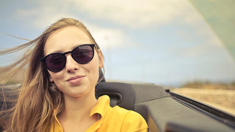Mujer en descapotable con el cabello al viento