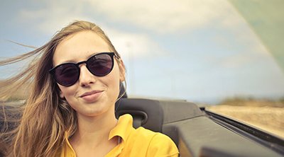 Mujer en descapotable con el cabello al viento