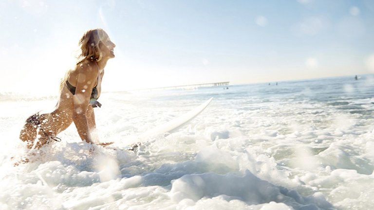 chica sentada en una amaca en la playa