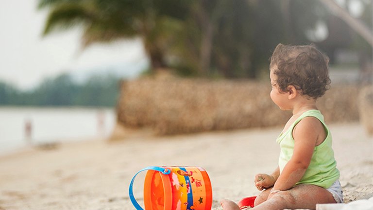 chica sentada en una amaca en la playa