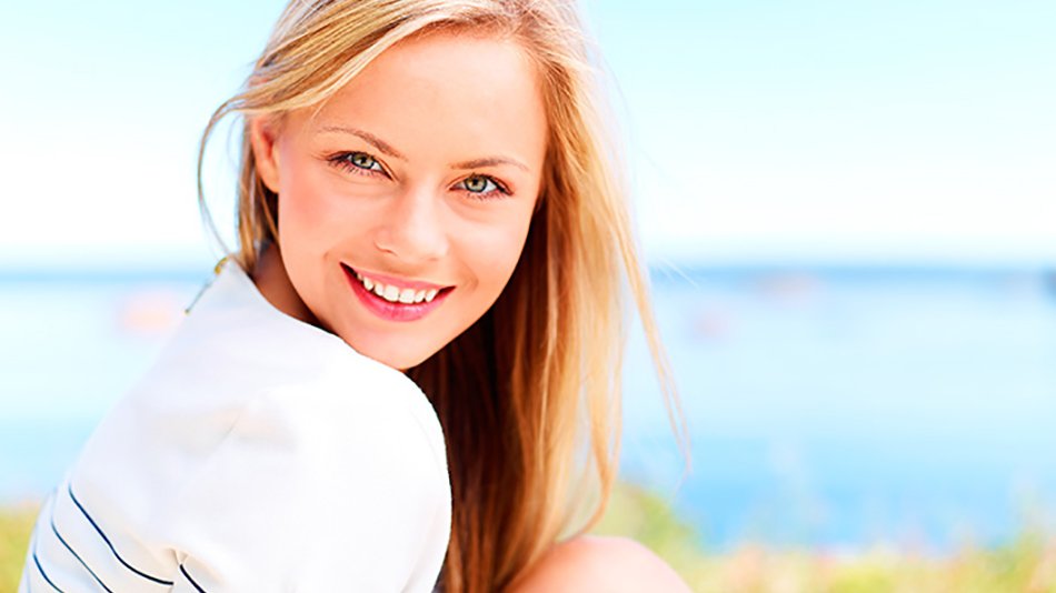 mujer sonriendo con mar de fondo