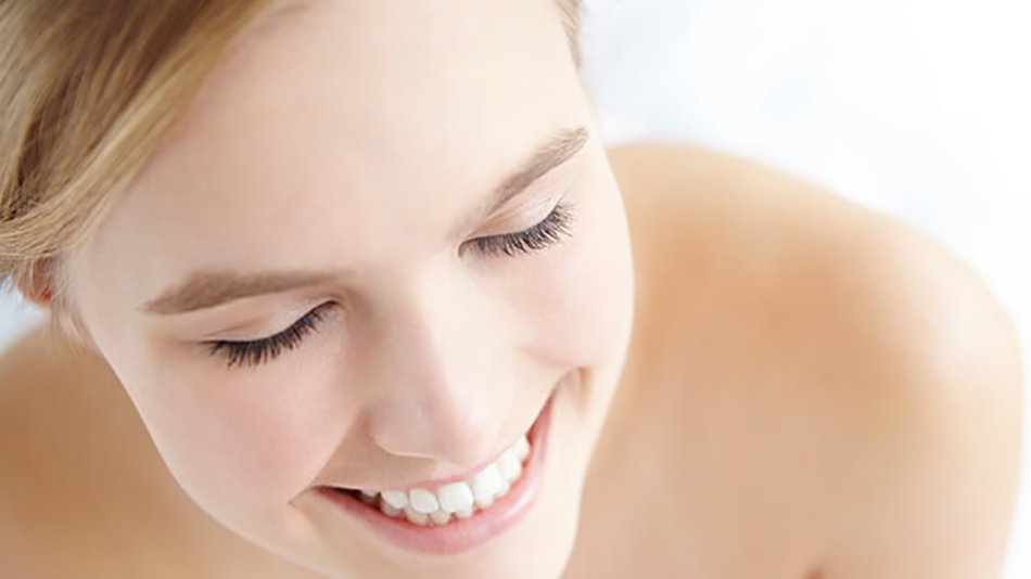 mujer rubia pelo recogido sonriendo ojos cerrados