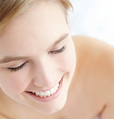 mujer rubia pelo recogido sonriendo ojos cerrados