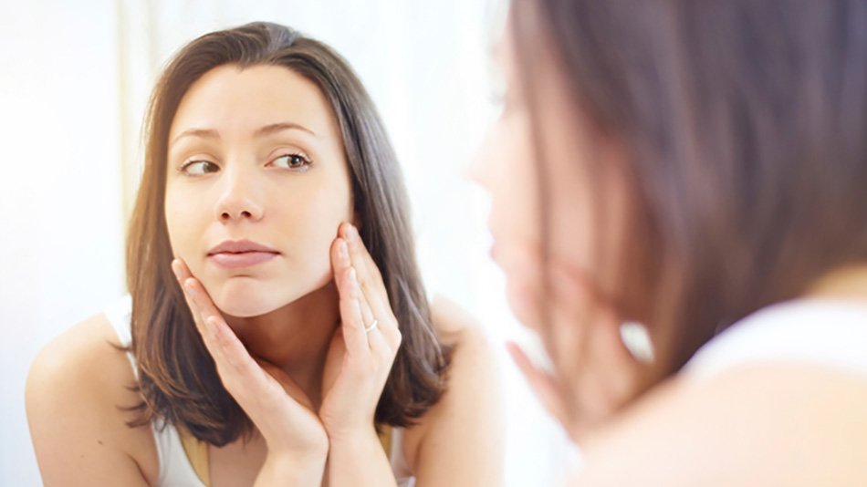 mujer morena mirándose al espejo