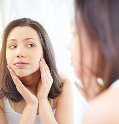 mujer morena mirándose al espejo